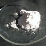 Lithium Carbonat liegt als weißes Pulver auf einer Glasschale