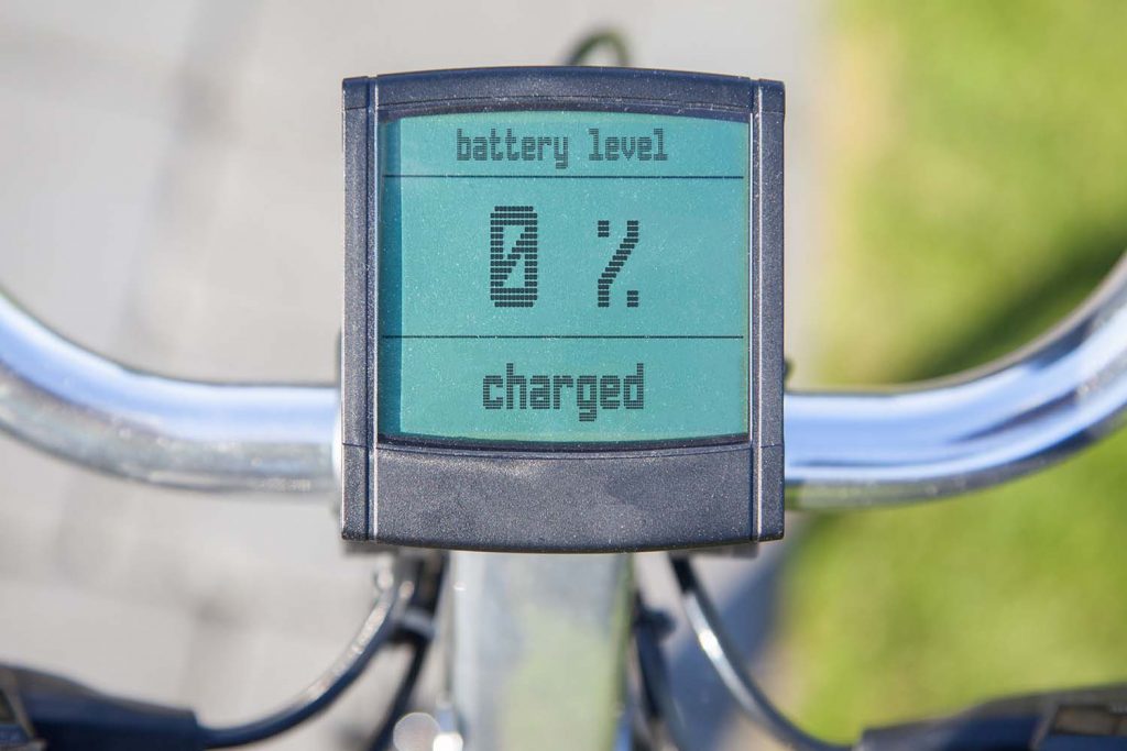 Draufsicht auf den Tacho eines E-Bikes mit Aufschrift "Battery Level, 0 % charged".